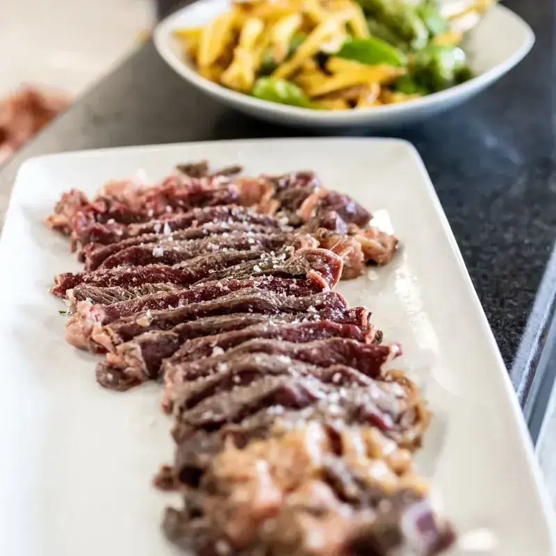 Carne cortada y servida en fuente, con patatas y pimientos